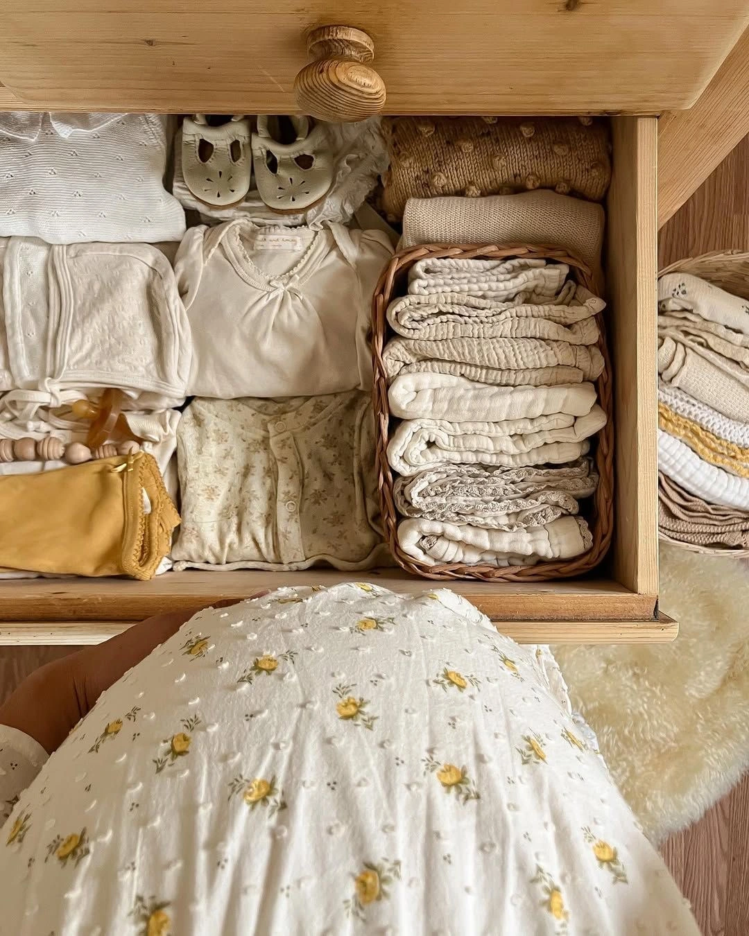 A neatly organized nursery drawer with soft baby clothes and blankets